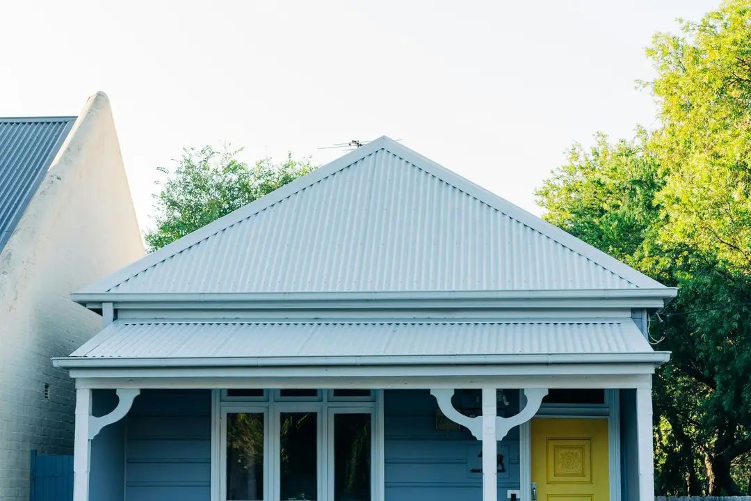 Painted weatherboard cottage with a white picket fence
