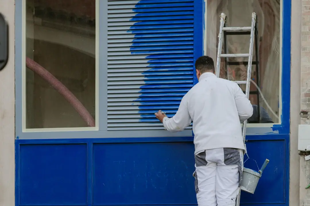 Painter on a ladder repainting a facade