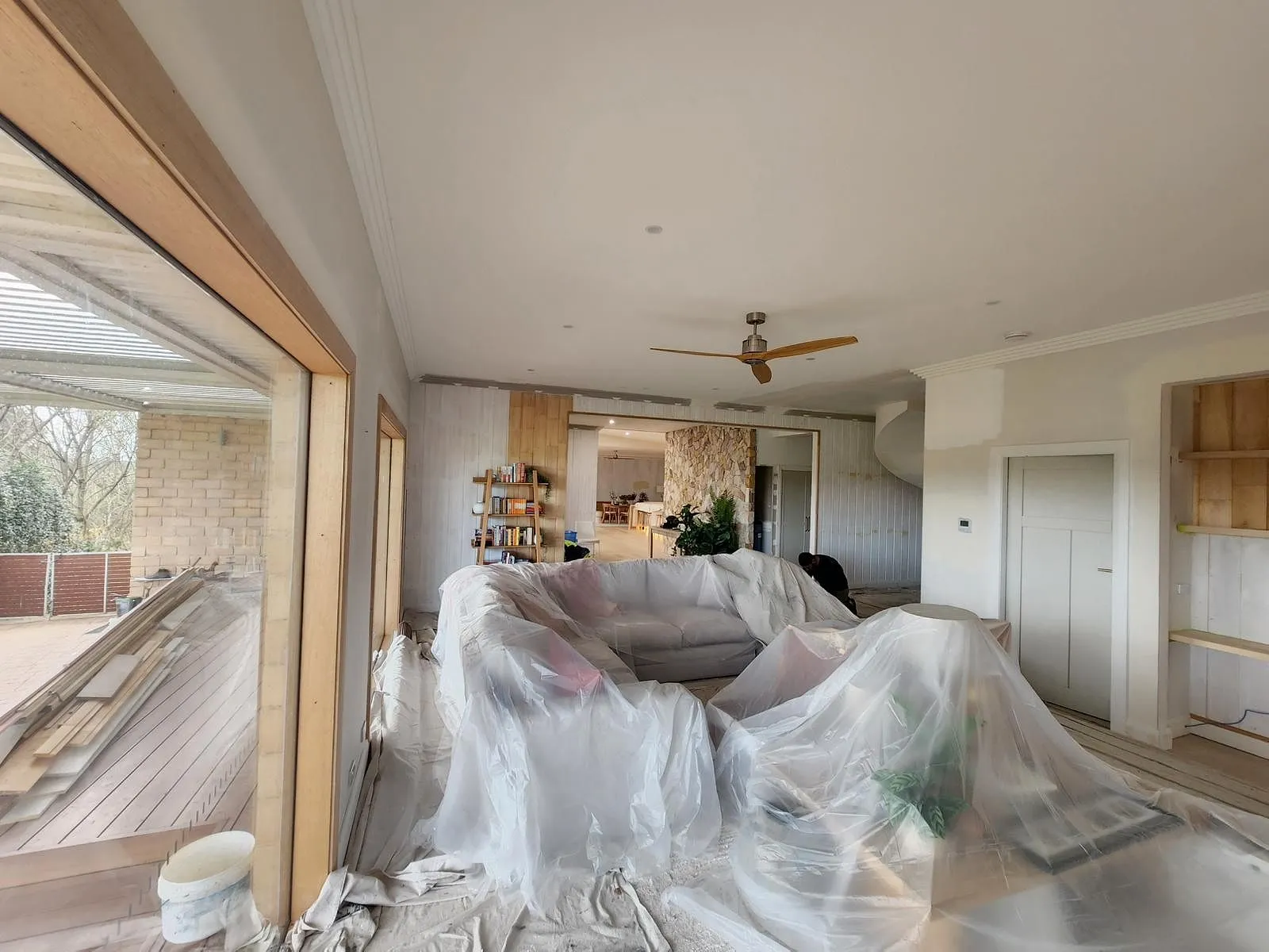 Furniture wrapped and floors sheeted before a tin is opened