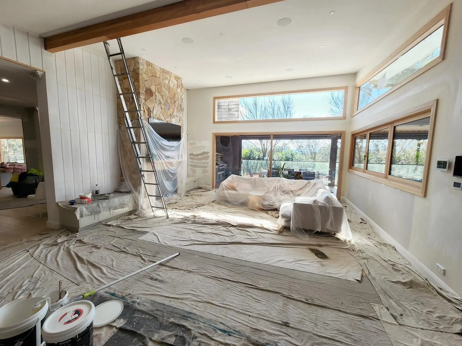 Living area sheeted and set up for painting